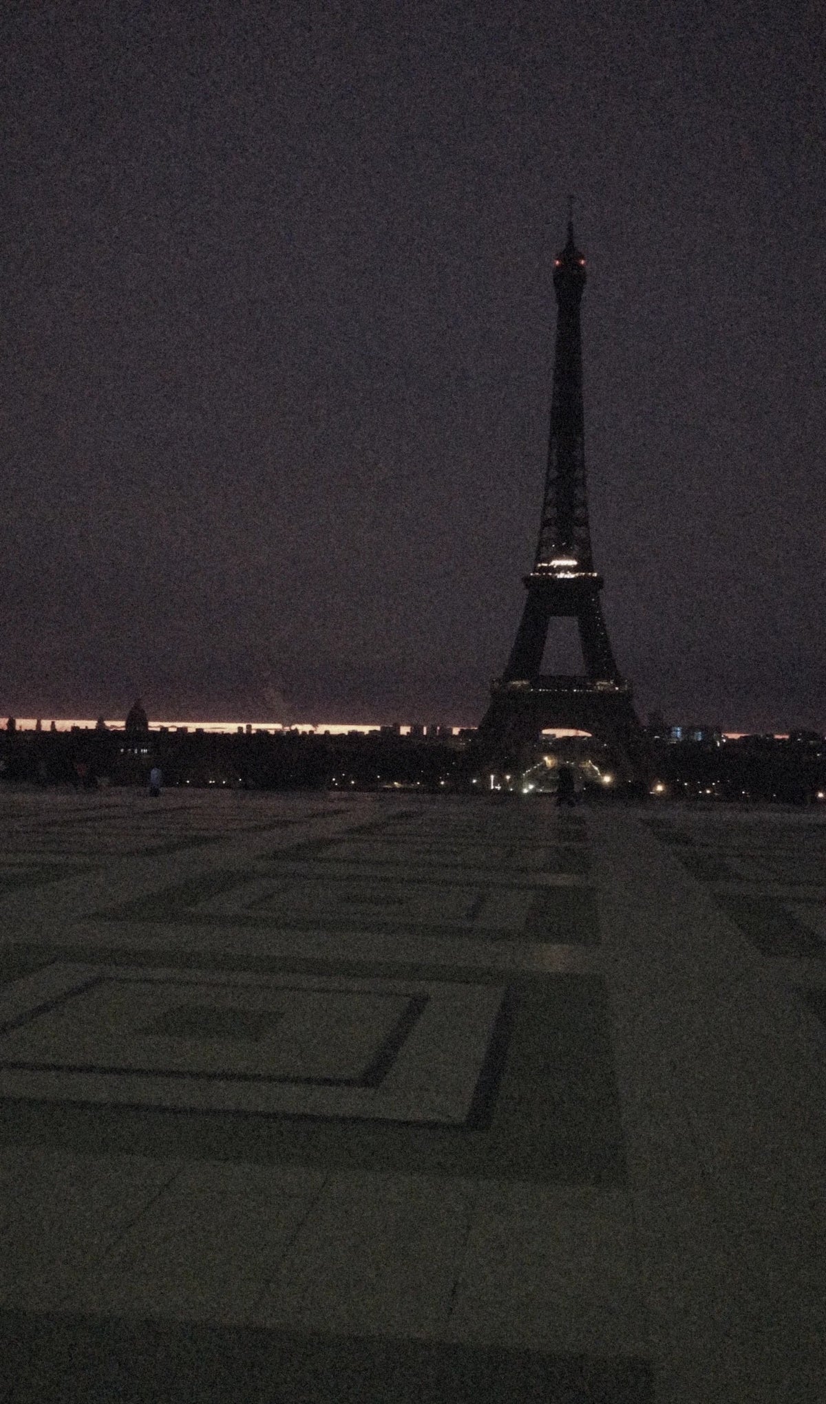 The Trocadéro esplanade before dawn in winter, the Eiffel Tower dark against a sky just turning red.