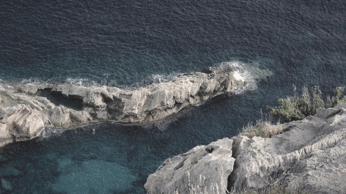 Clear blue water breaking against pale rocks on the north coast of Ibiza.